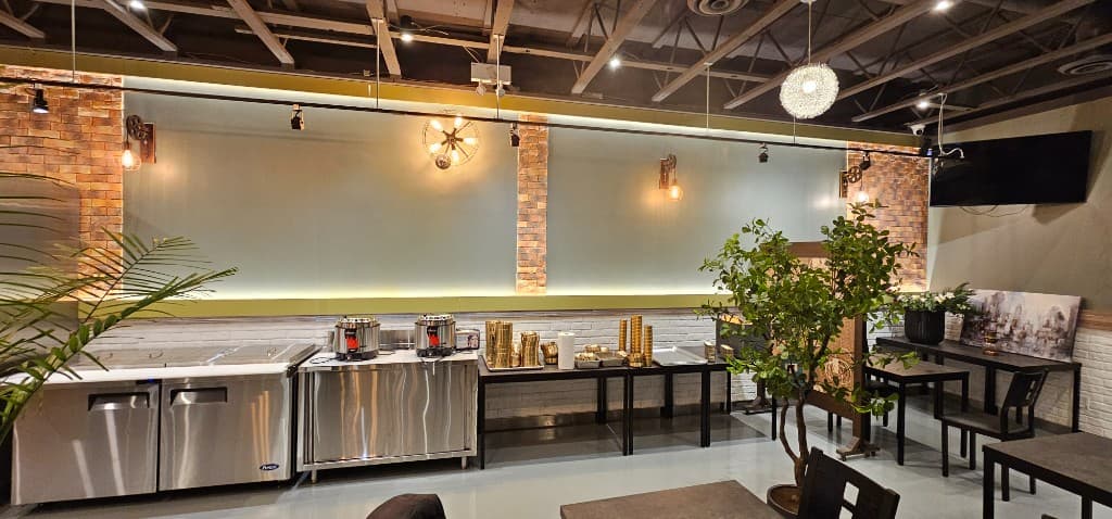 SizzlePan interior with warm accent lighting, brick columns, and service counter